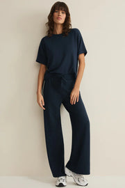 Woman wearing a navy blue outfit on a beige background