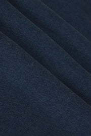 Woman wearing a navy blue denim wash sleeveless v-neck knit tank top with relaxed fit, fabric detail view