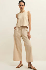 a woman wearing a light beige twill tanktop