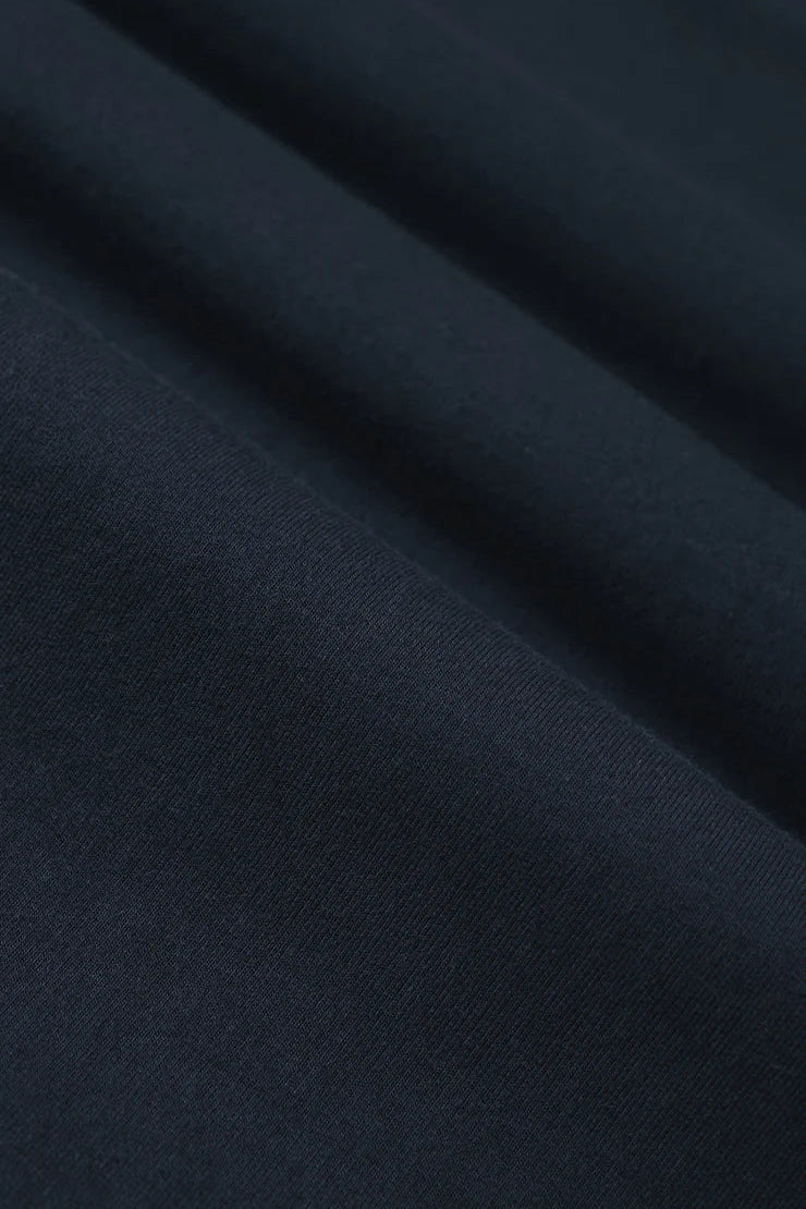 Woman wearing a navy short sleeve knit t-shirt, fabric detail view