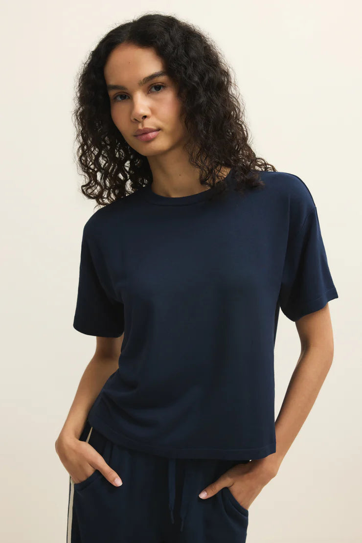 Woman wearing a navy short sleeve knit t-shirt, back view