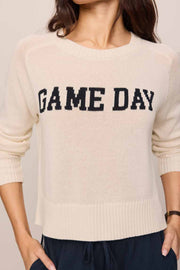 Woman wearing a beige 'GAME DAY' sweater