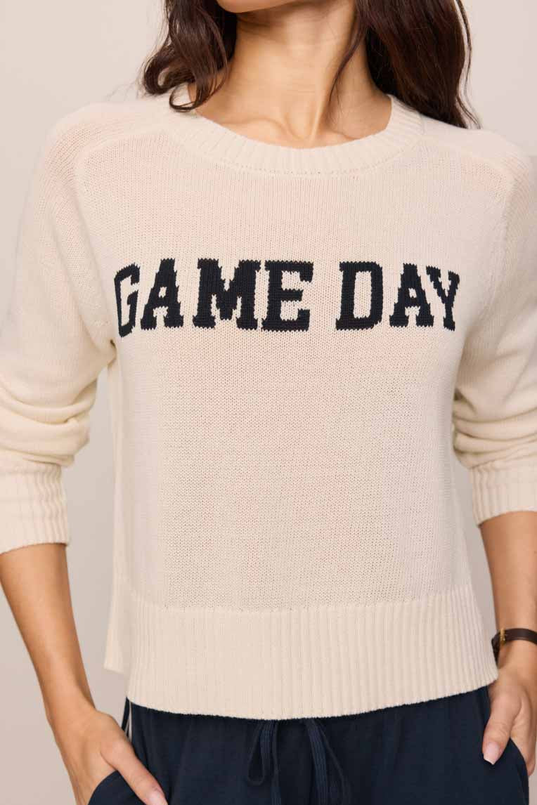 Woman wearing a beige 'GAME DAY' sweater