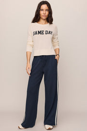 Woman wearing a beige 'GAME DAY' sweater