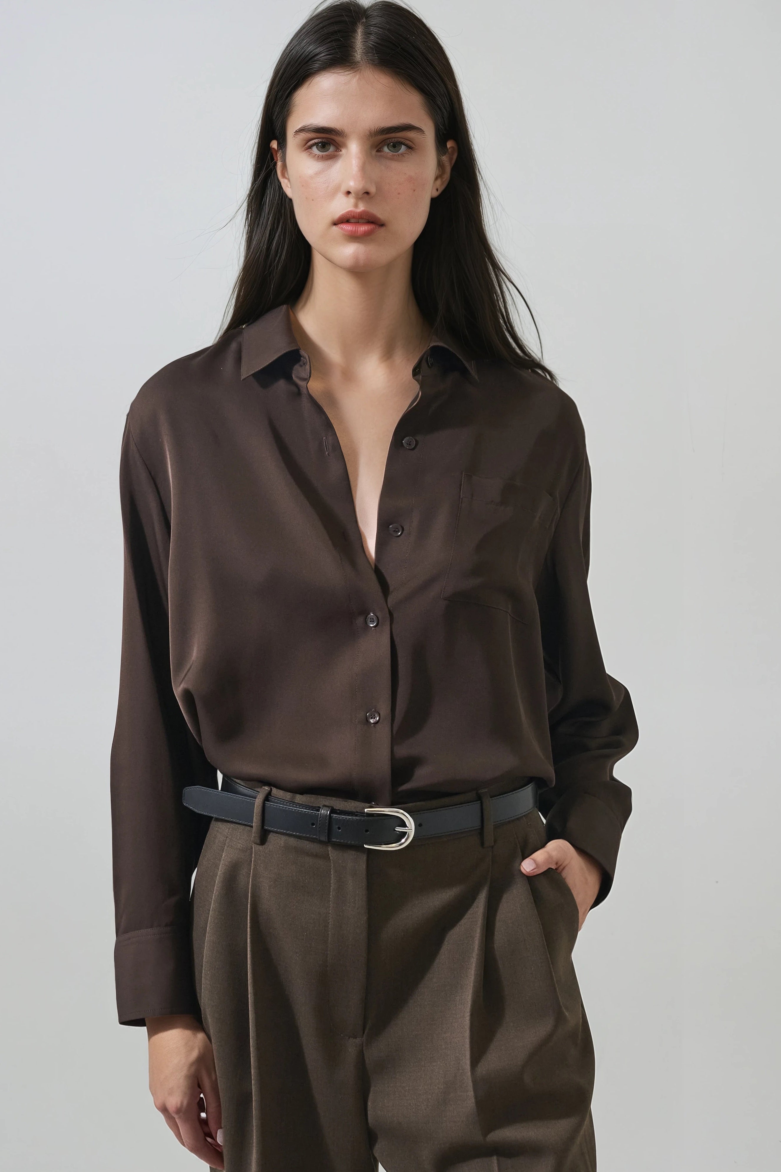 model wearing a dark brown long sleeve button down collard shirt with a relaxed fit 