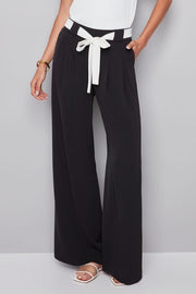 woman wearing a black pat with white shash belt 