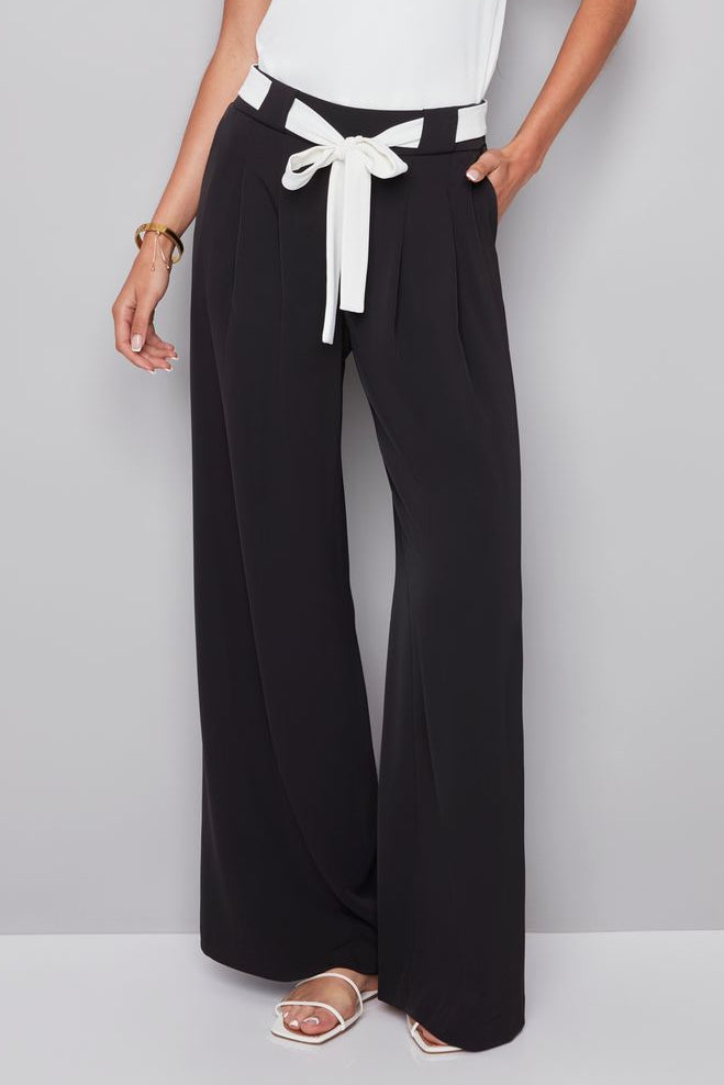 woman wearing a black pat with white shash belt 