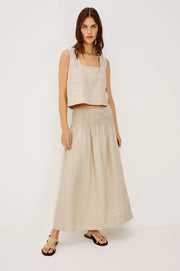 Woman wearing a beige linen midi skirt with a smocked elastic waistband, front