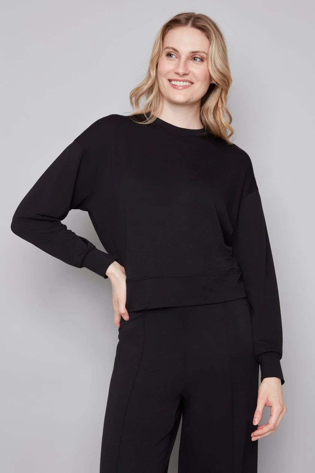 Woman wearing a black outfit against a plain background