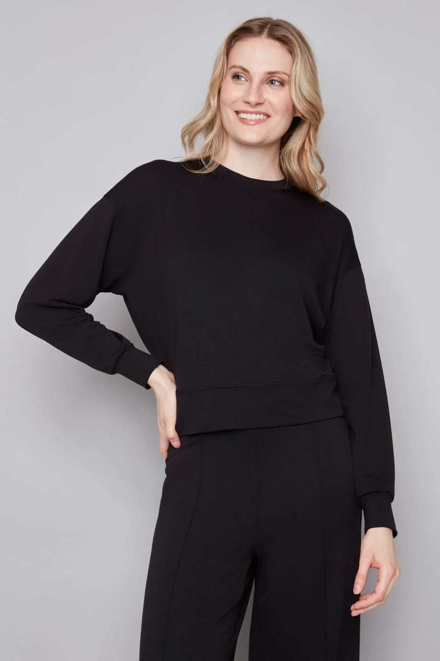 Woman wearing a black outfit against a plain background