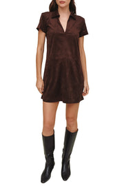 A woman modeling a short-sleeve collared mini dress in dark brown suede-like fabric, paired with black knee-high boots, against a plain white background.