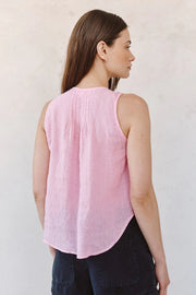 Woman wearing a pink sleeveless V-neck button-front blouse, back view