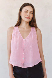Woman wearing a pink sleeveless V-neck button-front blouse, front view