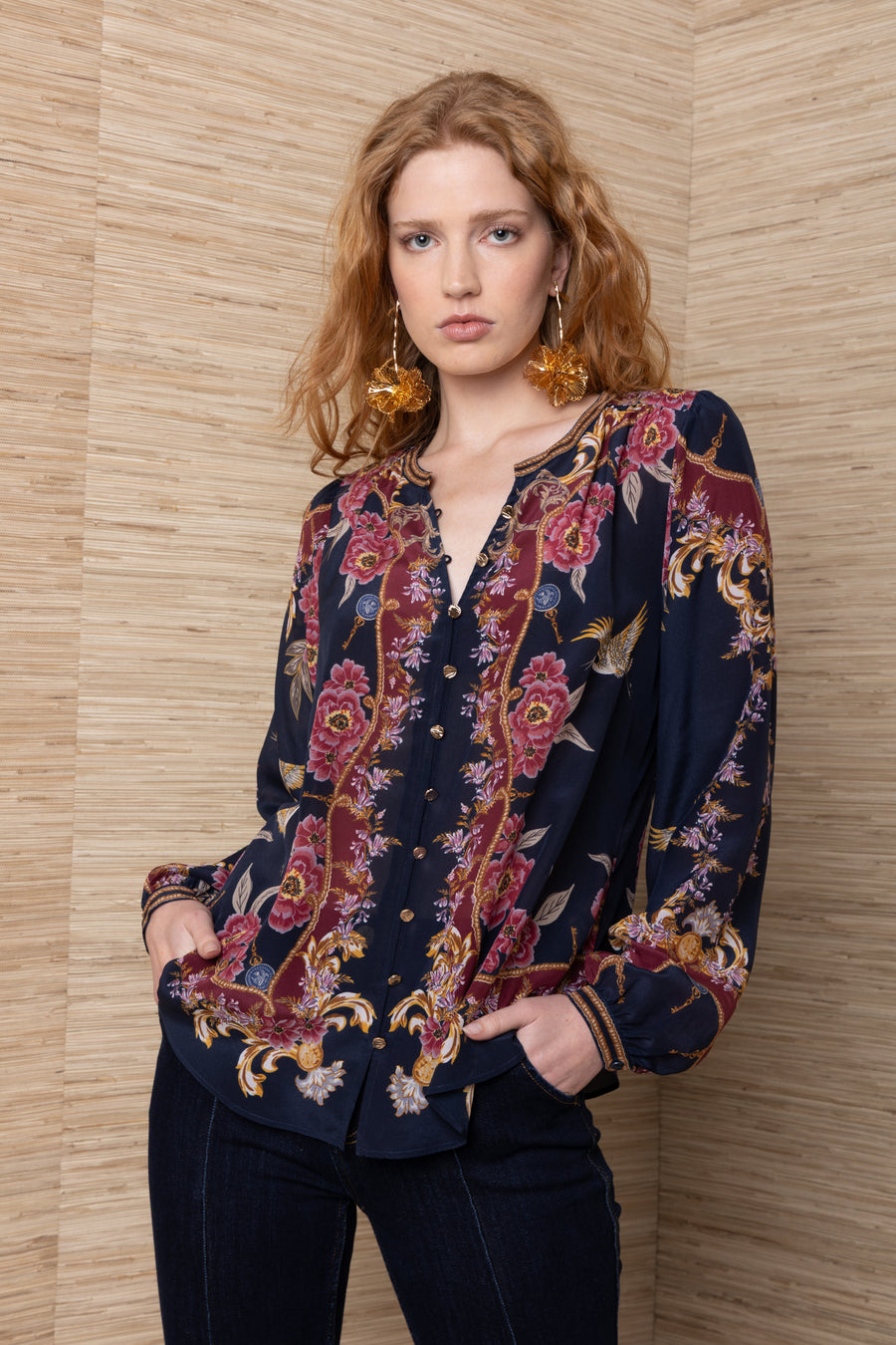 women wearing navy v neck button up blouse with gold and red floral designs and gold buttons 