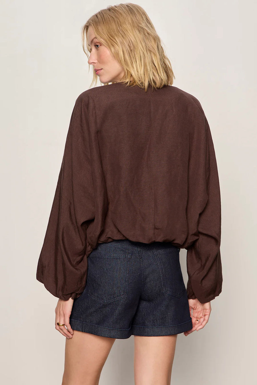 Woman wearing a lightweight rich chocolate brown bomber-style jacket with a relaxed fit. Features a zip-front closure, round neckline, dolman sleeves, elastic cuffs and waistband, and two front slant pockets, back