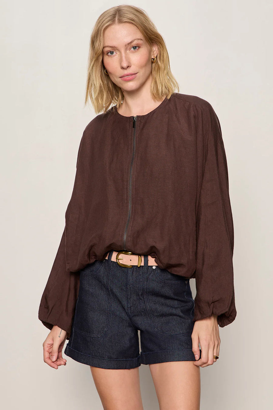 Woman wearing a lightweight rich chocolate brown bomber-style jacket with a relaxed fit. Features a zip-front closure, round neckline, dolman sleeves, elastic cuffs and waistband, and two front slant pockets, front
