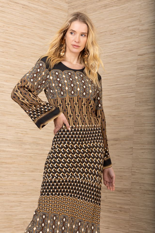 Front view of woman wearing a black, brown and mustard yellow patterned maxi jersey long sleeve dress.