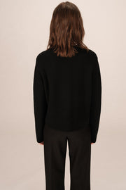 Back view of woman wearing a black cardigan 