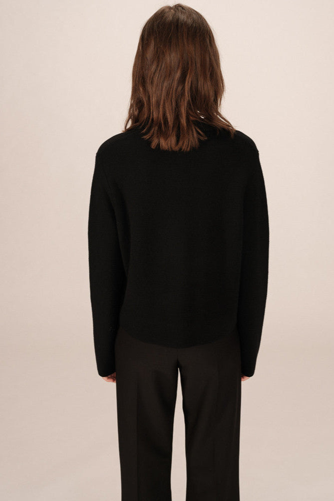 Back view of woman wearing a black cardigan 