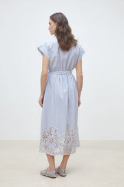 Woman wearing a light blue pinstripe short-sleeve shirt dress with a belted waist and embroidered hem, back view