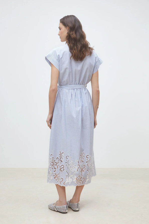 Woman wearing a light blue pinstripe short-sleeve shirt dress with a belted waist and embroidered hem, back view
