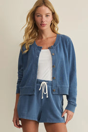 Woman wearing a blue long-sleeve button-front cardigan with a relaxed fit, front