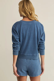 Woman wearing a blue long-sleeve button-front cardigan with a relaxed fit, back