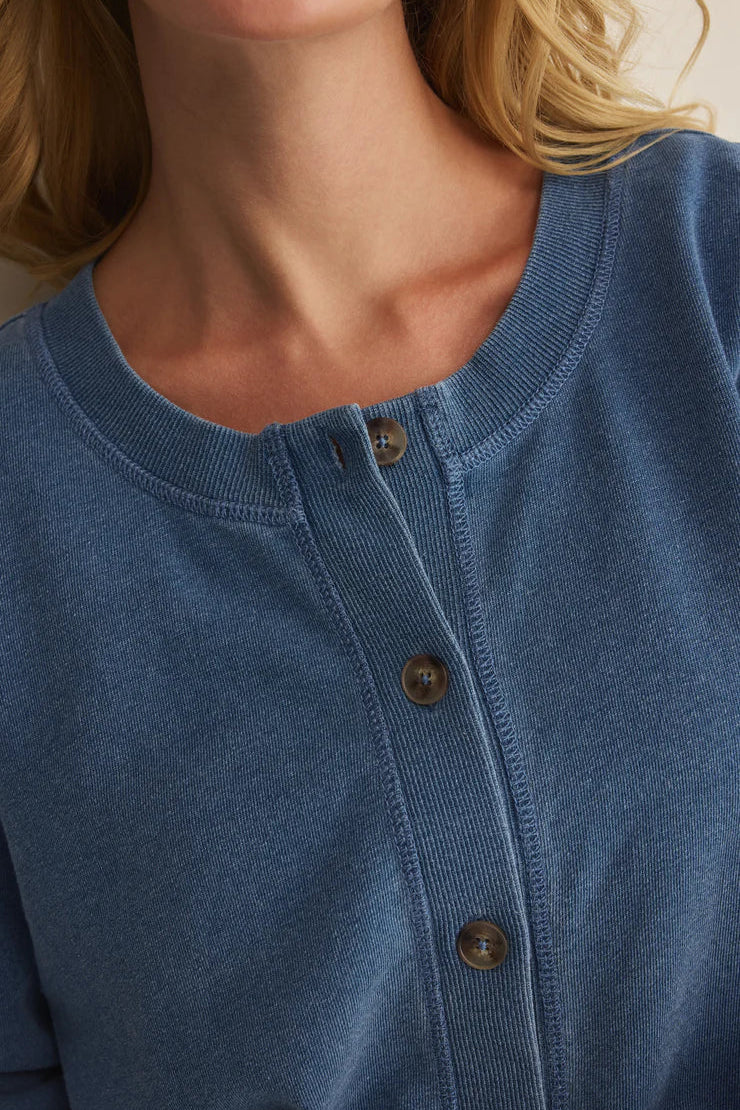 Woman wearing a blue long-sleeve button-front cardigan with a relaxed fit, detail