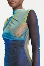 Zoom in of woman wearing a blue and green dress with sheer sleeves on a white background