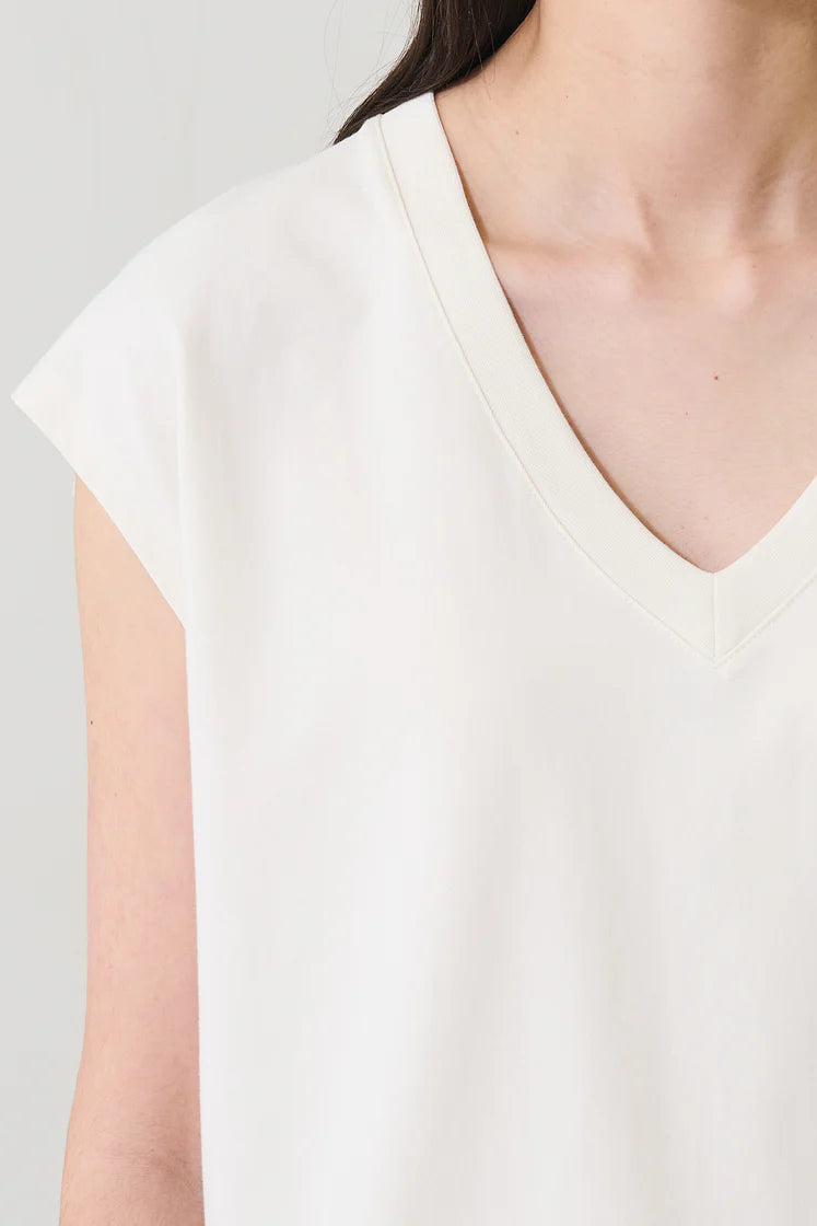 Woman wearing a cream V-neck short-sleeve top with a relaxed fit, detail view