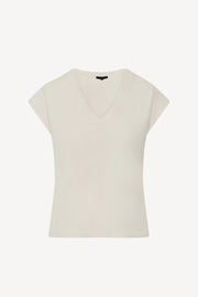 Woman wearing a cream V-neck short-sleeve top with a relaxed fit, front view
