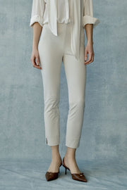 Woman wearing beige high-waisted slim-fit ankle-length pants, front
