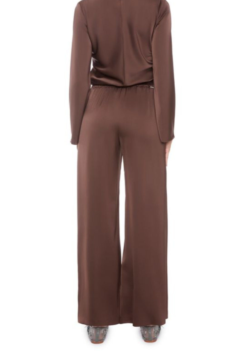 Back view of a woman wearing a brown satin set outfit on a white background