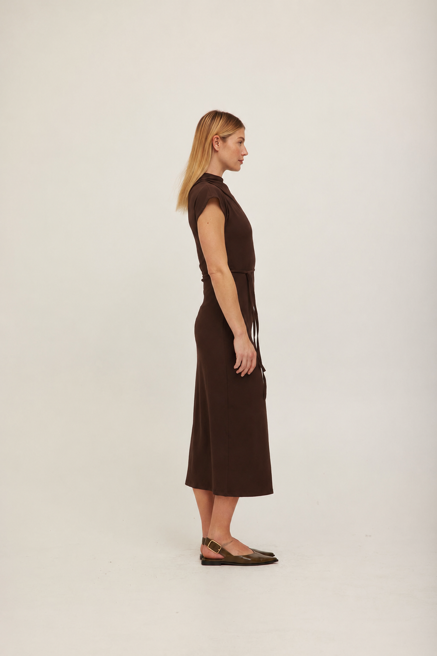A woman modeling a dark brown off-the-shoulder midi dress with a fitted waist and short sleeves. 
