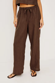 Woman wearing brown wide-leg drawstring pants with an elastic waistband, front