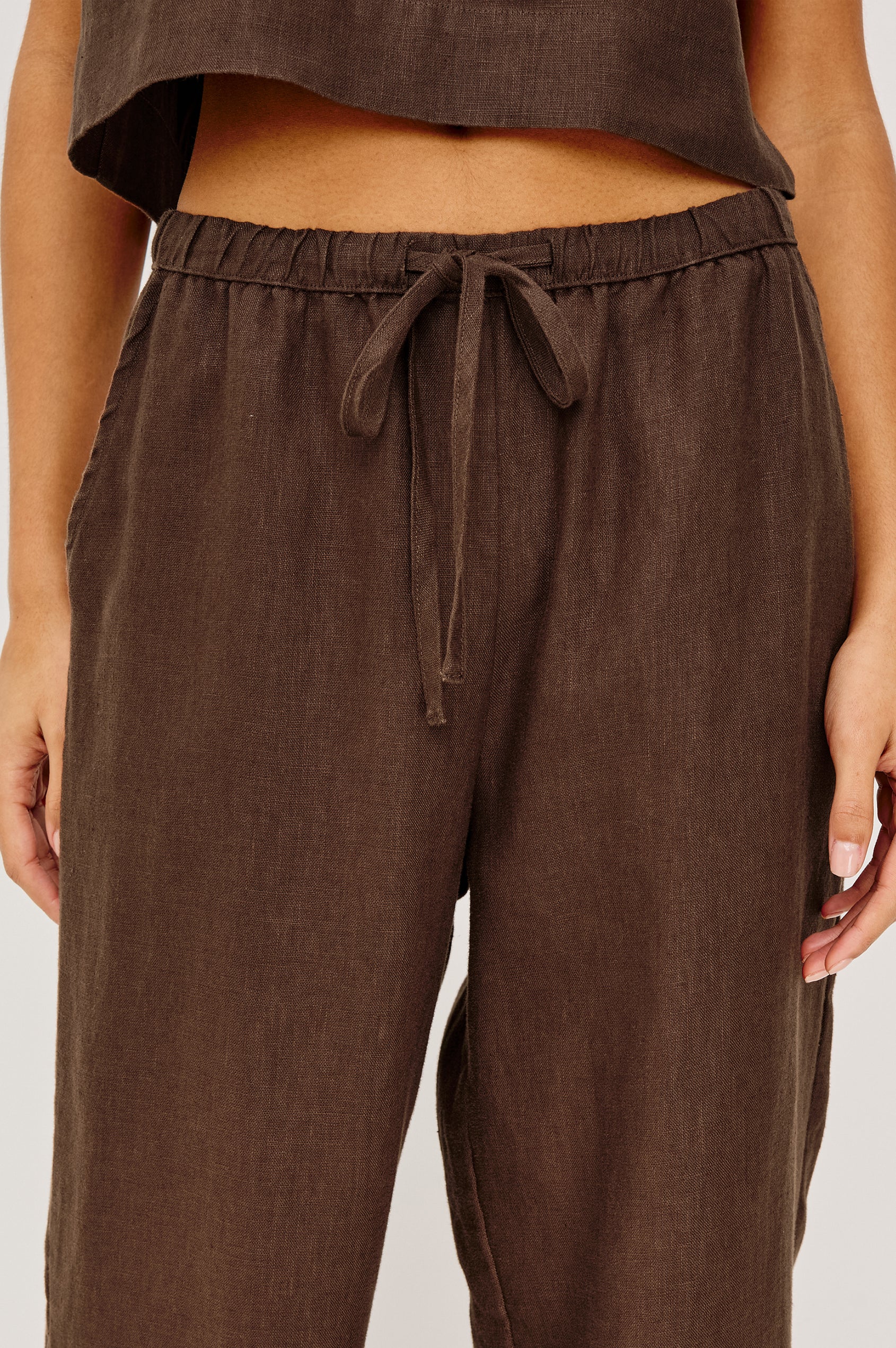 Woman wearing brown wide-leg drawstring pants with an elastic waistband, detail