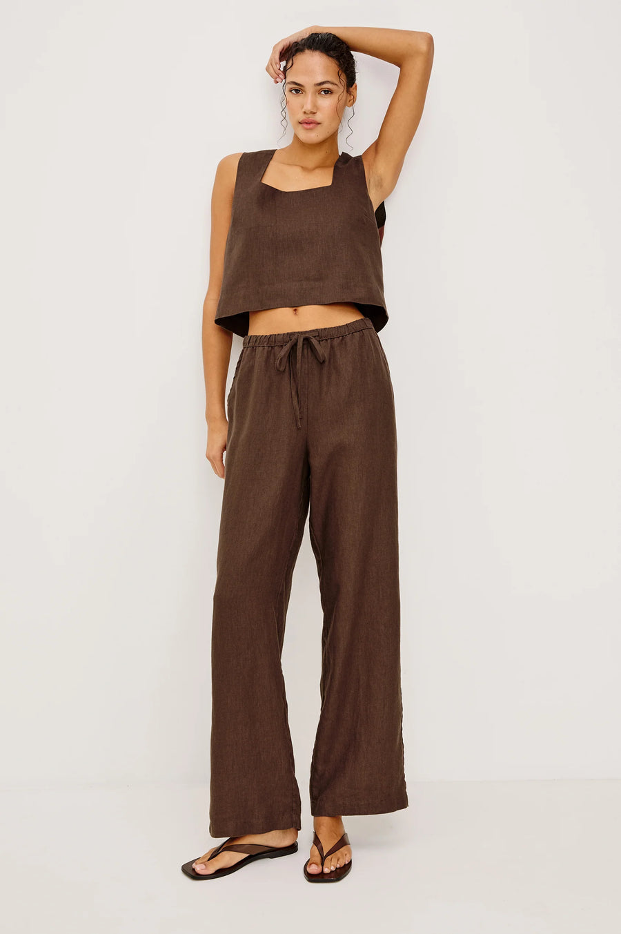 Woman wearing brown wide-leg drawstring pants with an elastic waistband, front