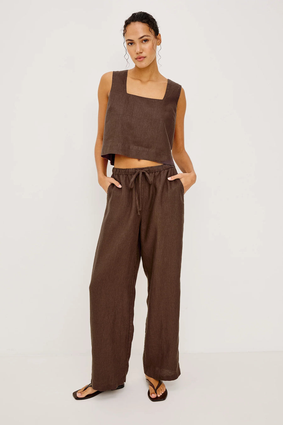 Woman wearing brown wide-leg drawstring pants with an elastic waistband, front