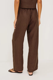 Woman wearing brown wide-leg drawstring pants with an elastic waistband, back