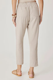 Woman wearing light beige cropped pull-on pants with an elastic drawstring waist, relaxed tapered fit, and front patch pockets, back