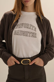 Person wearing a white t-shirt with 'FAVORITE DAUGHTER' text, 
