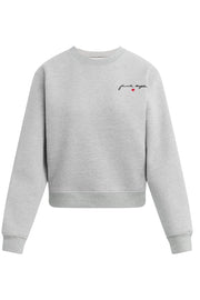 A light gray heather crewneck sweatshirt with a small black script logo and a tiny red heart on the left chest