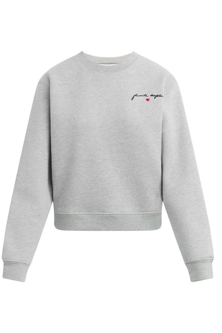 A light gray heather crewneck sweatshirt with a small black script logo and a tiny red heart on the left chest