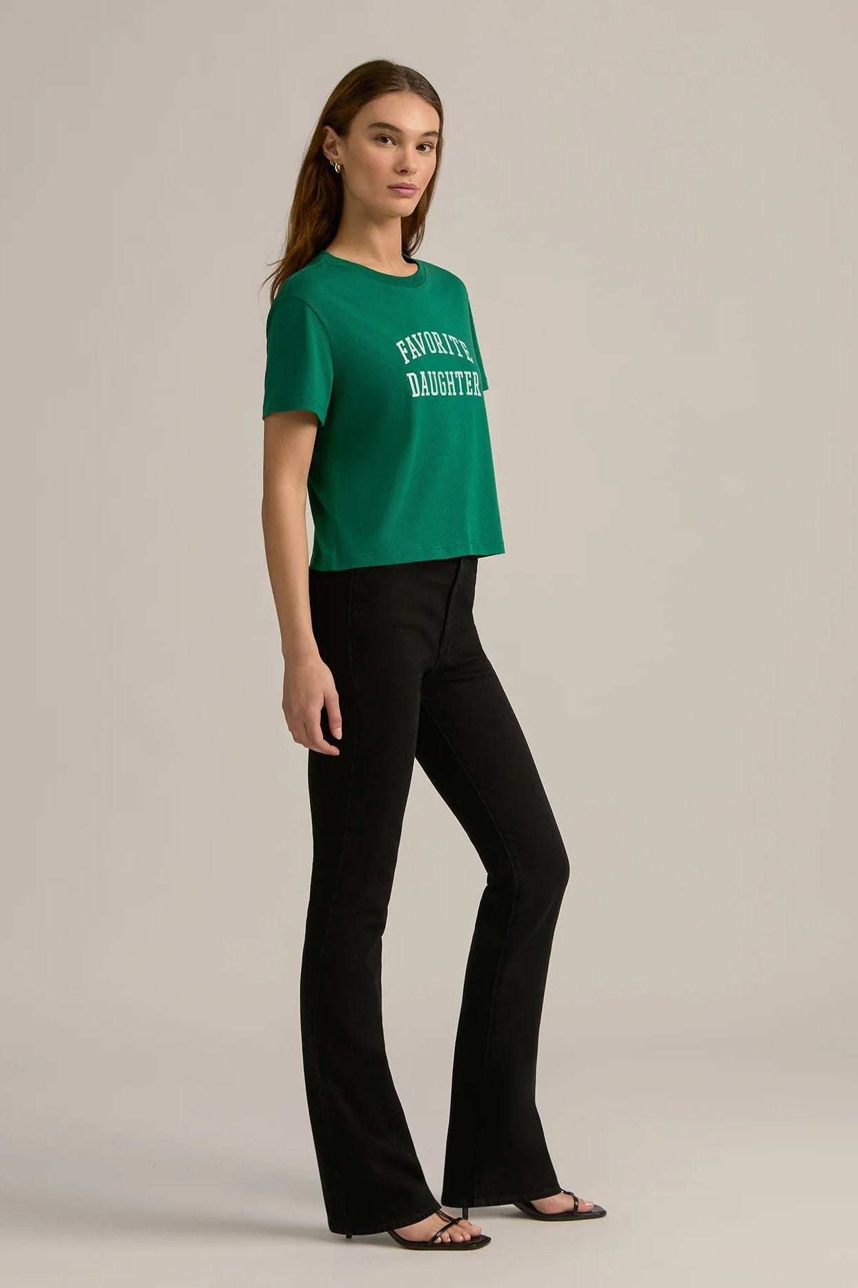 woman wearing an emerald green graphic cropped tee reading "FAVORITE DAUGHTER"