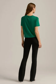 woman wearing an emerald green graphic cropped tee reading "FAVORITE DAUGHTER"