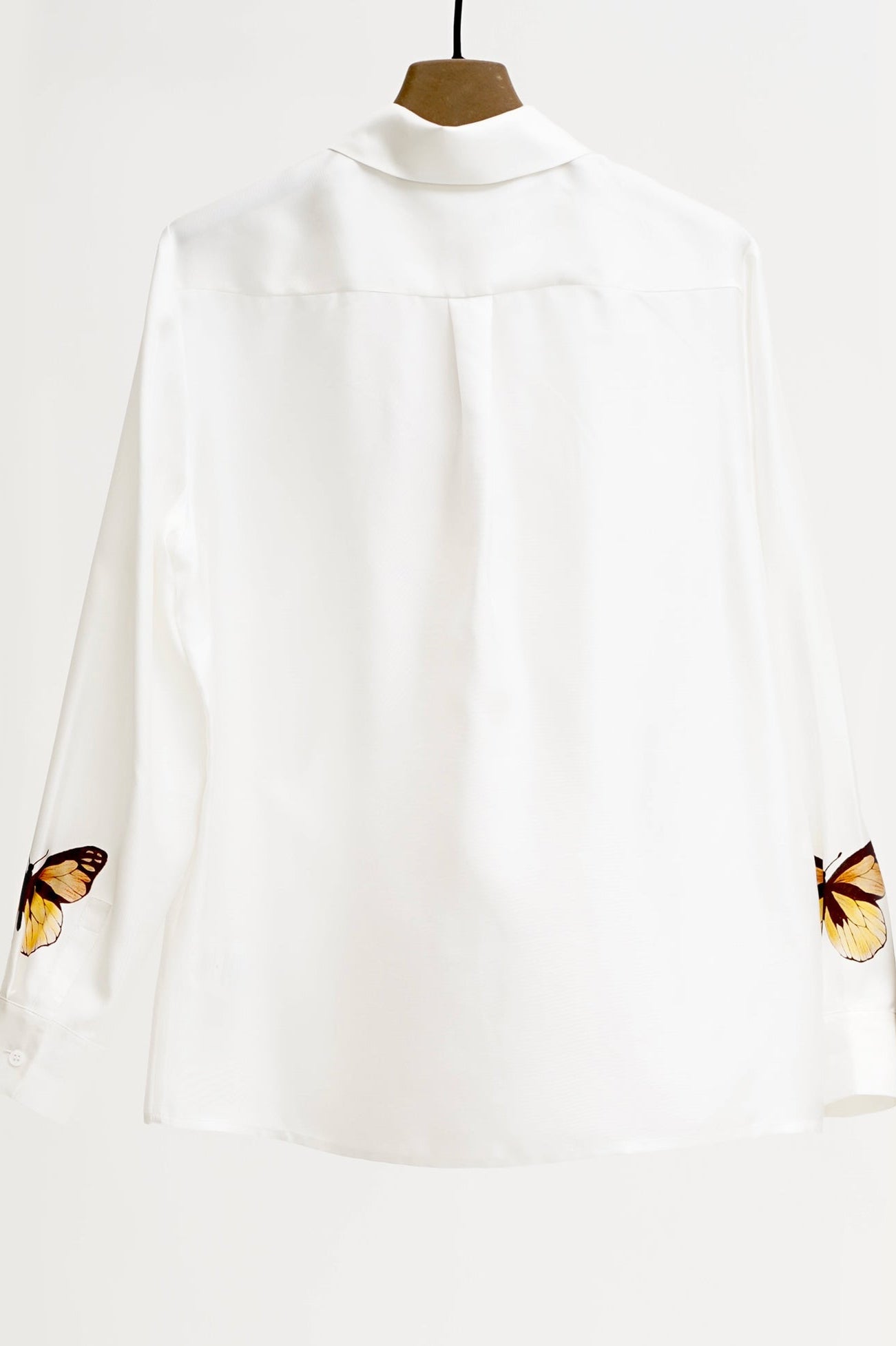 White blouse with butterfly designs on a white background