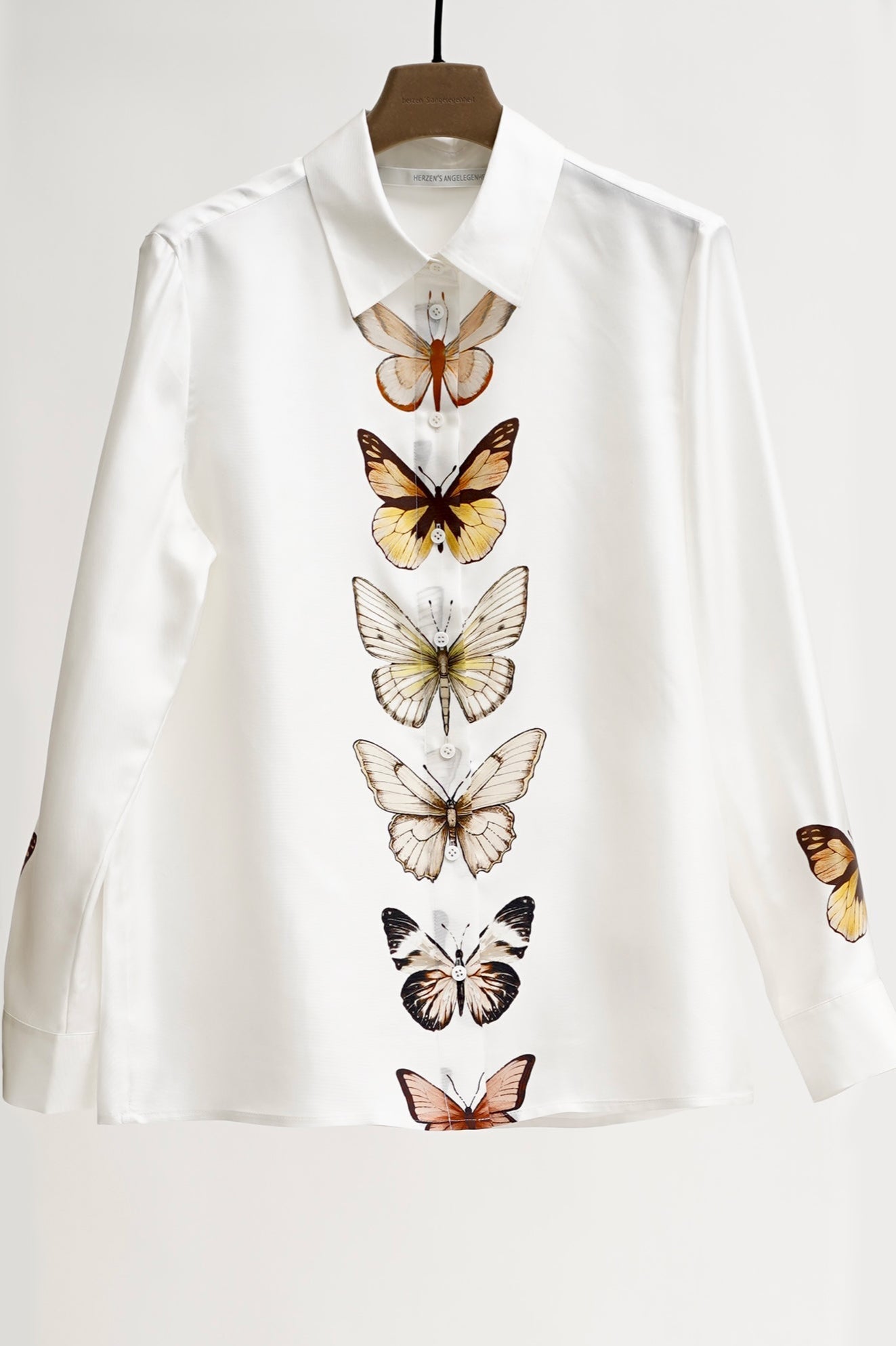 White shirt with butterfly designs on a white background