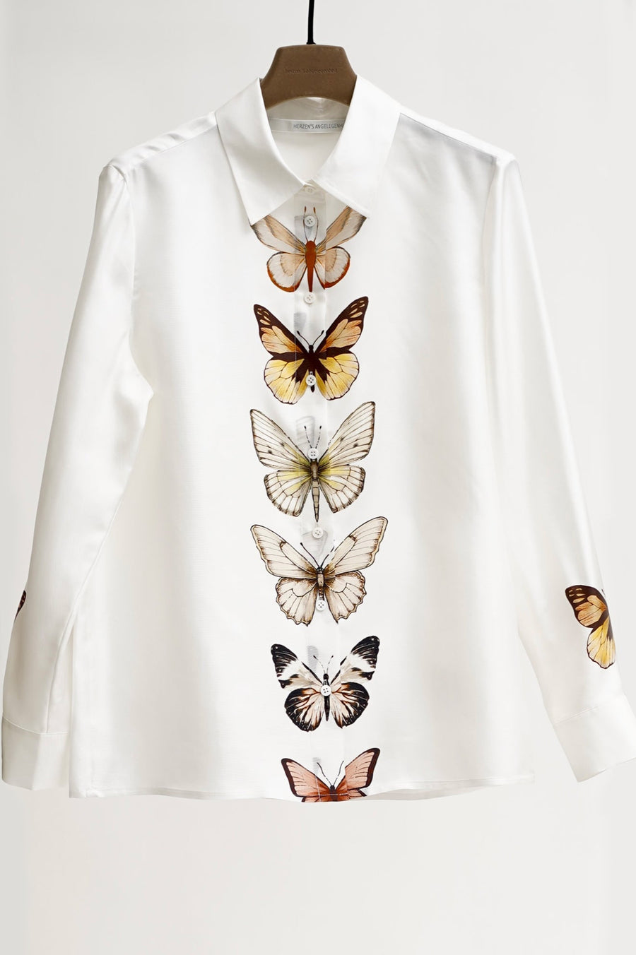 White shirt with butterfly designs on a white background
