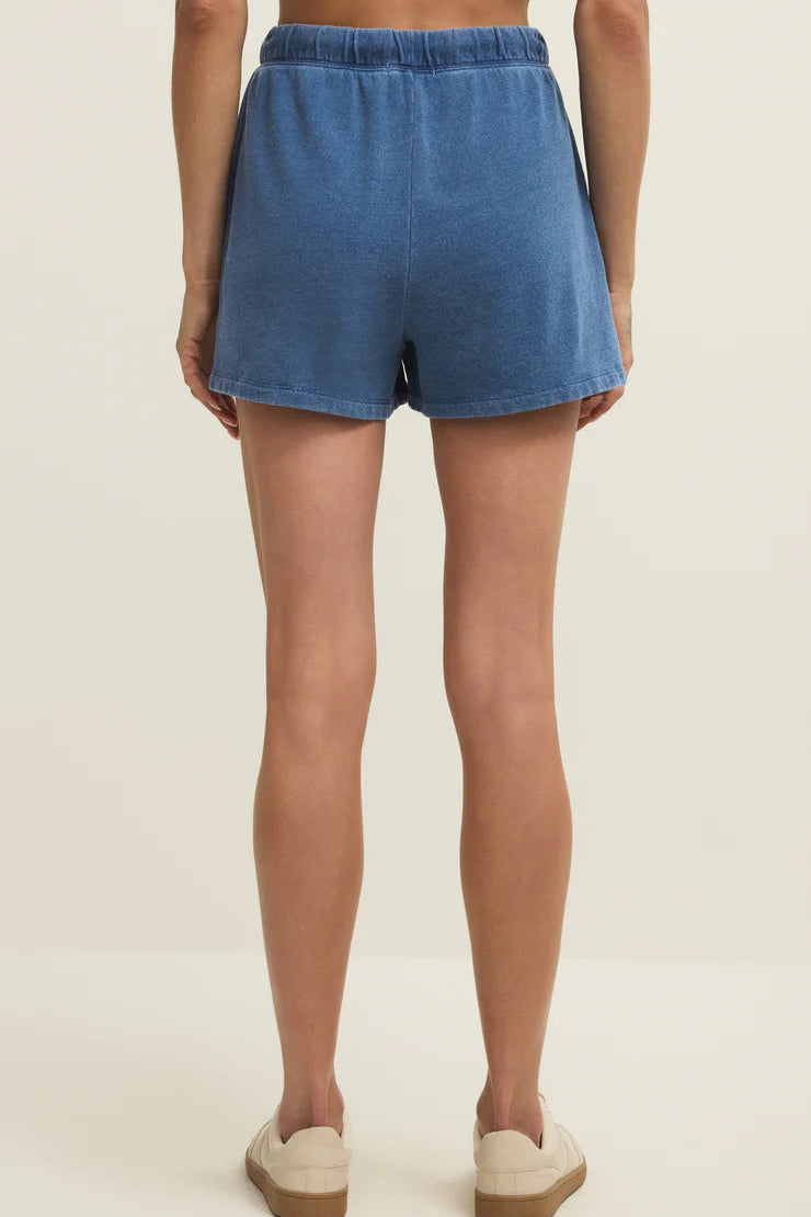Woman wearing blue elastic-waist drawstring shorts with a relaxed fit, back