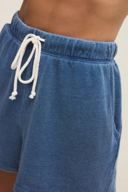 Woman wearing blue elastic-waist drawstring shorts with a relaxed fit, detail